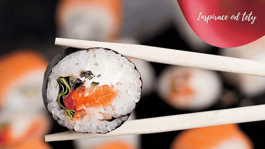 sushi drží osoba čínskými hůlkami