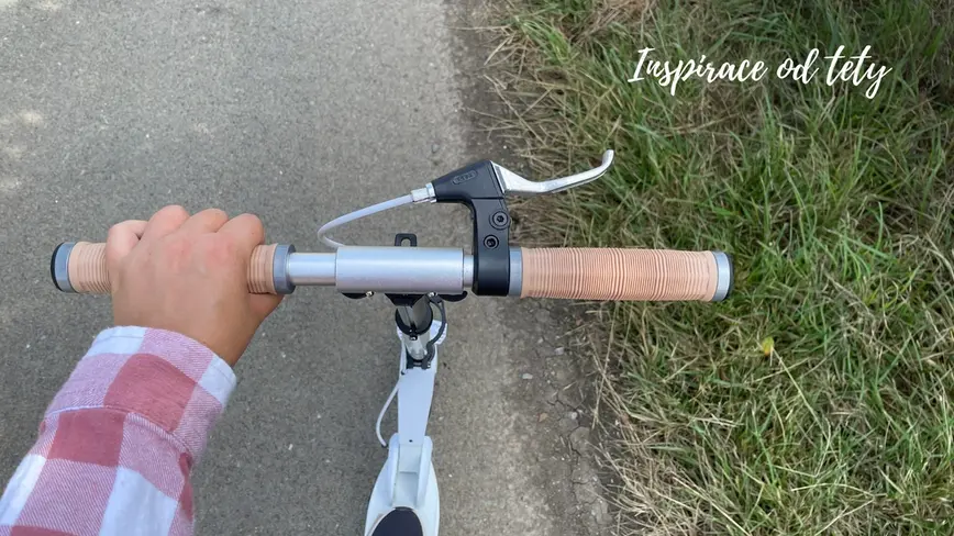 pohled na držení koloběžky cestou na výlet