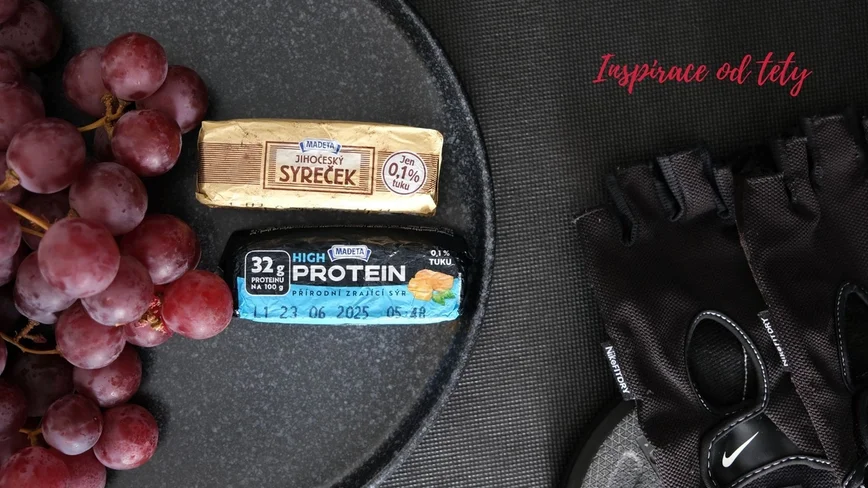 růžové hroznové víno se syrečky od Madety. Vedle položené fitness rukavice od značky Nike na kotouči na činky.