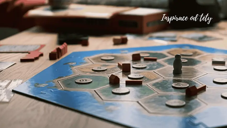 Hra Catan na stole, hráči mají rozehranou deskovoui hru
